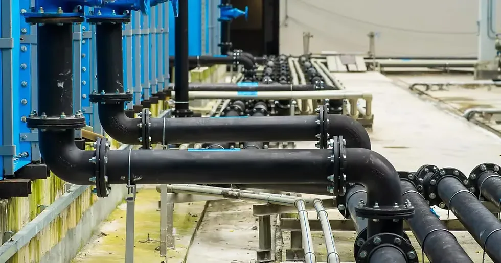 A run of flanged water mains and gate valves along a water-treatment channel — plumbing contractor insurance in West Virginia